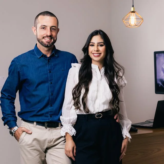 Dr. Gabriel Bruzadelli e Dra. Luana Rambaldi, sorrindo lado a lado no consultório.