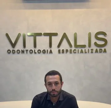 Letreiro dourado Vittalis Odontologia Especializada na parede da recepção.